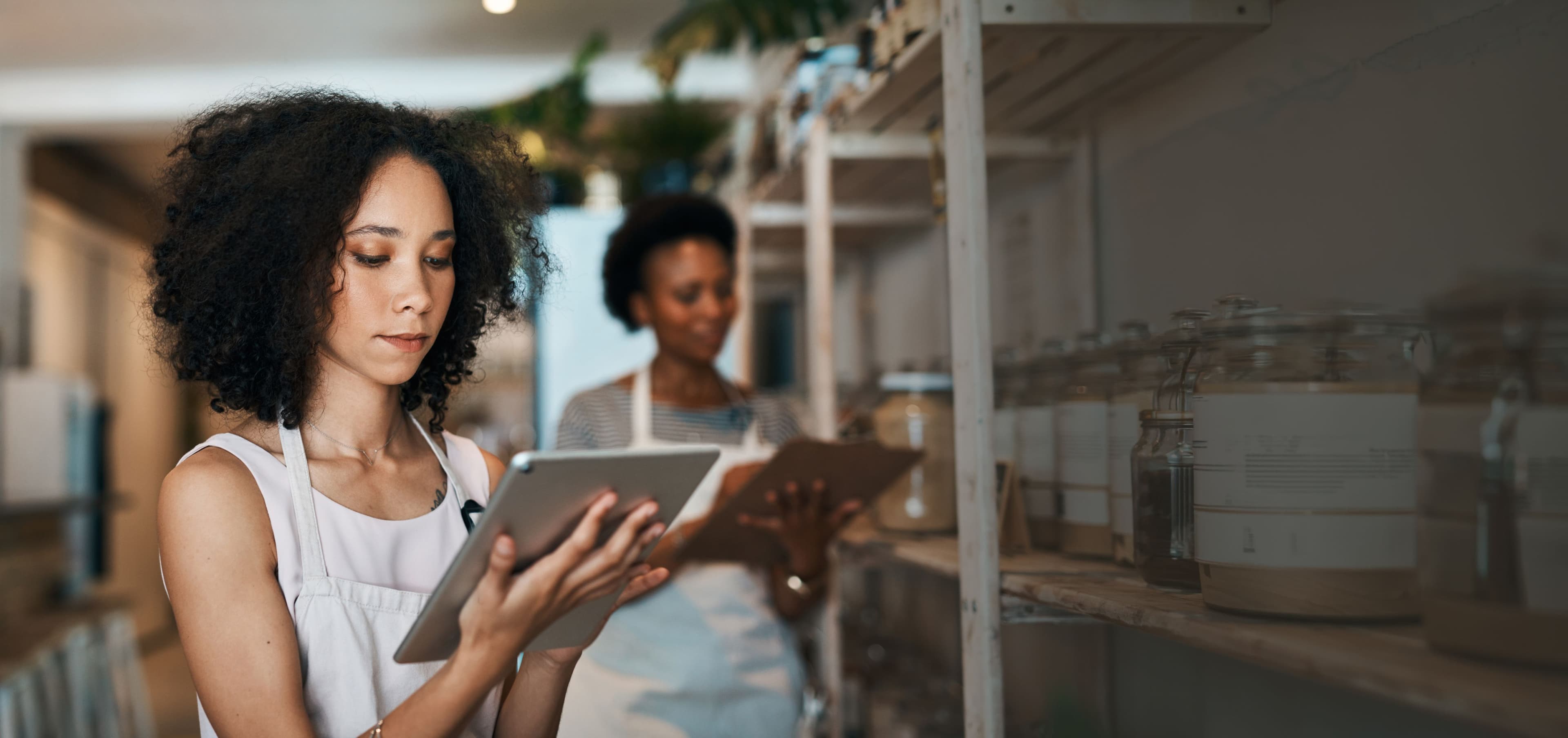woman near shelf holding an ipad